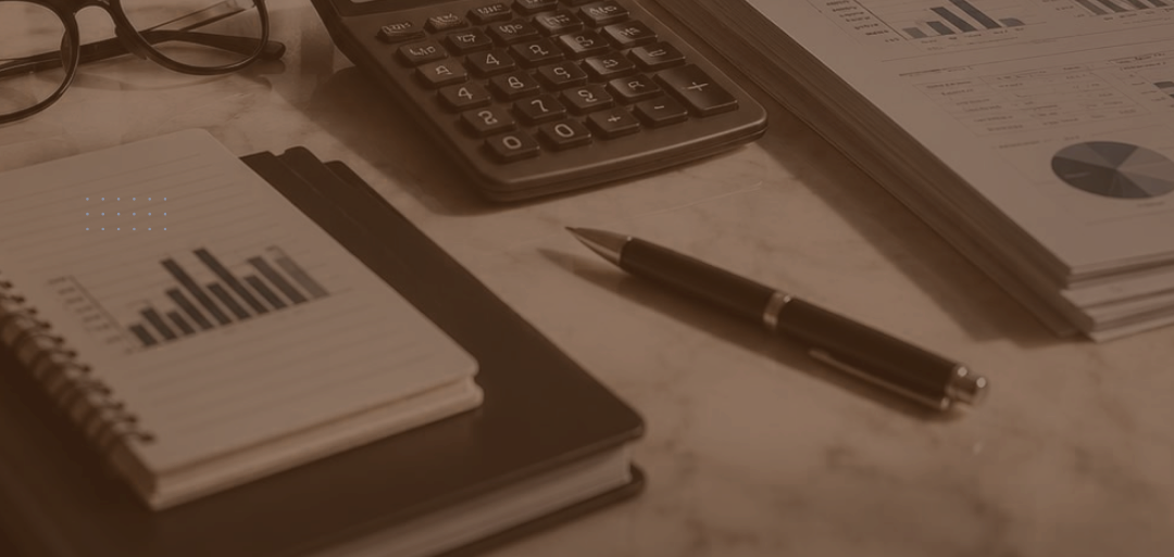 Libros de contabilidad, calculadora y lentes sobre el escritorio
